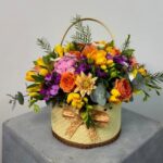 Görseldeki ürün; doğal hasır dokulu, saplı bir sepet içerisinde sunulan, sarı frezya, turuncu çardak güller, pembe ortanca ve mor mevsim çiçekleriyle harmanlanmış, tam bir "Bahçe Esintisi" aranjmanıdır. Malatya yerel pazarında bu ürün, özellikle "nostaljik", "samimi" ve "doğal" hediye arayanları yakalayacaktır. İşte internet siteniz için hazırladığım çalışma: