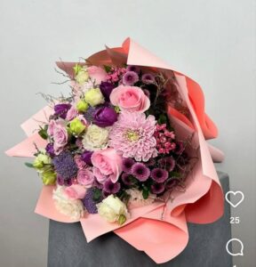 Görseldeki ürün; pudra pembesi ithal güller, iri kafalı pembe krizantemler, mor lila tonlarında mevsim çiçekleri ve minik dolgu çiçeklerinin (Anastasia/Dahlia) somon rengi katlı ambalajla birleştiği, oldukça romantik ve feminen bir bukettir. Malatya’daki internet siteniz için bu buketi "zarafet" ve "özel gün" odağında şöyle kurgulayabiliriz: