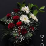 Görseldeki ürün; siyah-gold çizgili silindir kutu içerisinde kırmızı güller, beyaz gerberalar, bolca cipso (gelin nefesi) ve ortasında romantik bir kadife kalp figürü barındıran, kontrastı yüksek ve oldukça şık bir kutu aranjmanıdır.